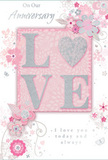 This anniversary card offers a tender tribute to long-lasting love, its design as soft and intimate as a pastel bouquet prepared for delivery around Brompton. At the heart of the card, the word LOVE appears in elegant, raised glitter letters, each line edged with a fine shimmer that catches the light like early morning sun on dewy petals. The O is transformed into a silver-textured heart, gleaming just a little brighter, as if to highlight the emotional centre of the message. The background is a gentle blush pink that creates a cocoon of warmth around the central motif, allowing the glitter and silver accents to stand out while preserving an overall feeling of calm. Surrounding the word LOVE, delicate blooms in blush, mauve, and creamy ivory unfurl with the softness of a watercolour painting, their edges blurred slightly to suggest movement and light. Slender vines, tiny petals, and graceful swirls weave between the flowers, echoing the flowing lines you might see in a florist's carefully styled anniversary arrangement. Small, subtle butterflies and flourishes add a touch of whimsy, enhancing the sense of an English spring garden tucked into paper form, much like the gardens that dot the Brompton area. The sentiments On Our Anniversary and I love you today and always are rendered in refined, understated script, supporting the design rather than competing with it. You can almost feel the smooth cardstock, the gentle rise of the glitter letters, and the quiet joy this card brings to an anniversary celebration shared in a Brompton home.